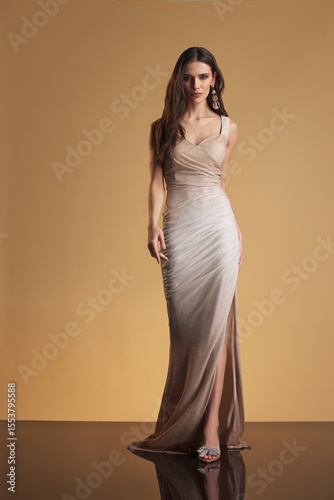 Obraz na plátně Full-length portrait of a glamorous female model in a metallic champagne evening