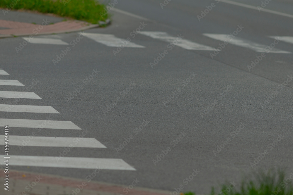 Obraz premium Here is a detailed closeup view of a crosswalk located on the side of a busy road, highlighting its various features and surroundings