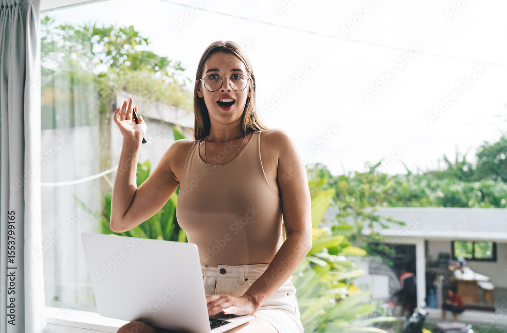 custom made wallpaper toronto digitalSurprised freelancer woman gestures with pen, expressing sudden idea or remote breakthrough while engaged with digital tools in flexible, sunlit tech-friendly setting.