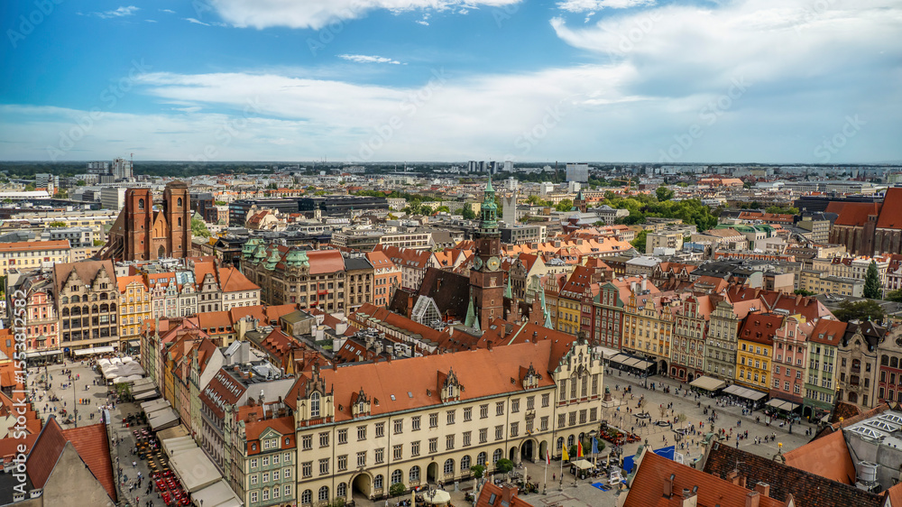 Obraz premium A panoramic overhead view showcasing the historic downtown area, filled with vibrant buildings, churches, and architectural landmarks under a clear blue sky, Wroclaw, Poland