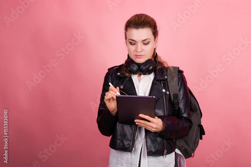Woman with headphones, listening to music, fashion model in studio posing, music genre, smiling, rock, metal music , tablet