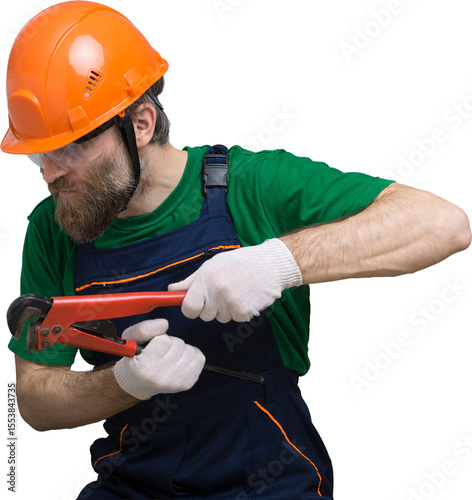 A male plumber installs a radiator in the heating system of an apartment. Guy in overalls and a gas wrench.