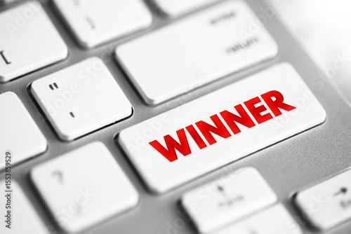 Winner - individual or team who emerges victorious or achieves success in a competition or challenge, text concept button on keyboard