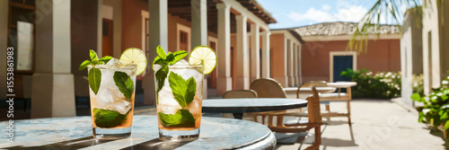 Refreshing mojitos served outdoors with vibrant garnishes in a small tropical town café, long banner
