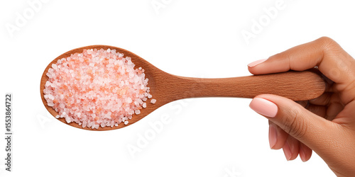 Wooden spoon of Himalayan pink salt crystals in hand
