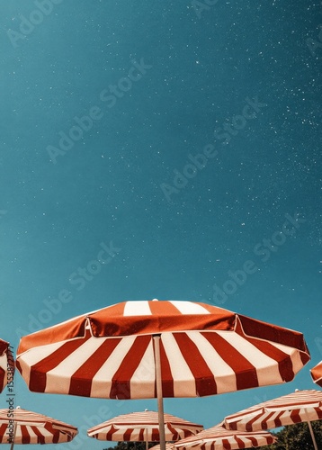 Bright Summer Afternoon With Striped Umbrellas Under Clear Blue Sky