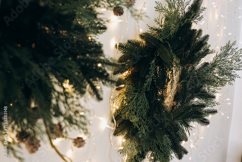 Beautifully decorated Christmas wreaths hanging on a wall with glowing fairy lights