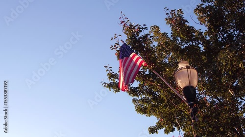 American Flag hanging on light post in small town 4k
