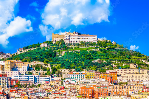 Aerial view of Naples, Italy, capturing its vibrant and colorful urban fabric with tightly packed buildings, historic rooftops, and Mediterranean charm spreading across the hillsides