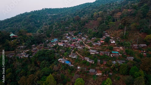 Aerial landscape revealing tranquil mountain village nestled on verdant slopes of doi mae salong, northern thailand, representing peaceful rural settlement amid lush landscape photo