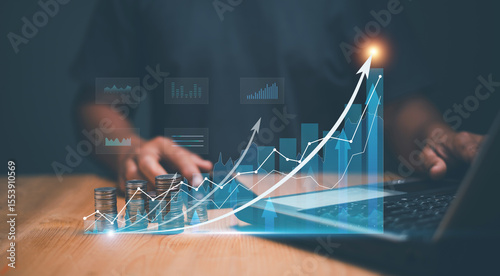 Business growth and investment concept. Businessman using laptop for analyzing business growth on financial graph. Stack of coins. Target for business investment. Development to success motivation.