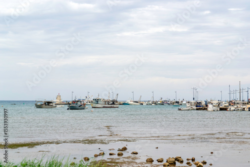 Fishing boats vessels,  fishing trawler anchored in a small harbor under cloudy sky, Adriatic coast. fishing industry, shipping.difficult navigation, problematic divergence of ships, copy space