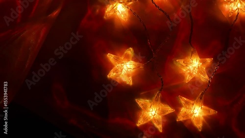 garlands of stars on red fabric. Decorative Star Lights with glittering fabric.Christmas wallpaper in red tones. 4k footage