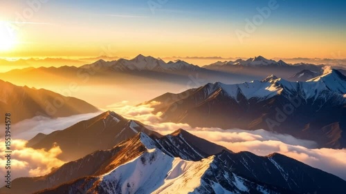 Sunrise over snowy mountain range, aerial view, clouds below