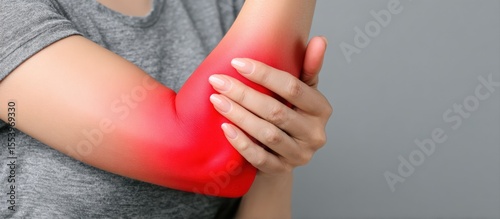 Wallpaper Mural Close up of a woman holding her painful arm against a grey background, highlighted in red to indicate the area of discomfort Torontodigital.ca