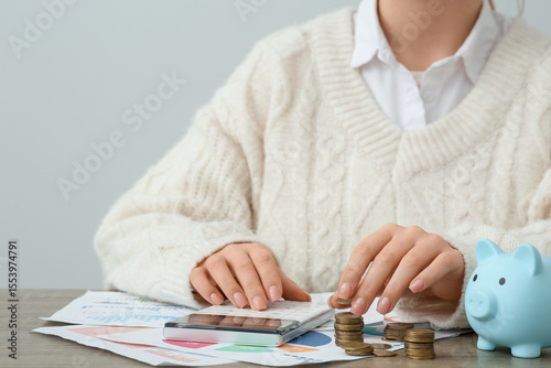 Woman with coins using calc...