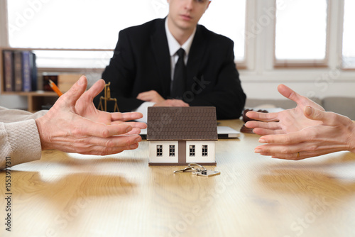 Mature couple dividing house at divorce lawyer's office, closeup