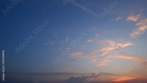 A breathtaking sunset sky timelapse with rich hues of deep blue fading into warm oranges and pink clouds, creating a serene and calming atmosphere as daylight gently disappears. Time-lapse.
