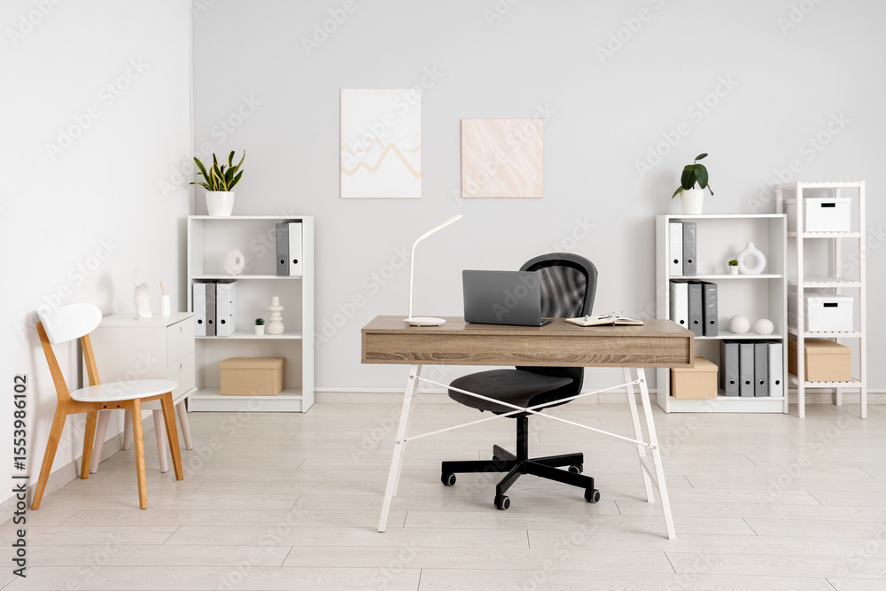 Fototapeta premium Interior of light office with workplace and shelf units