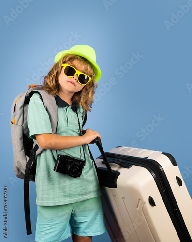 Kids travel. Happy child boy in travel hat with suitcases isolated on studio backgraund. Travel lifestyle and dreams of travel.
