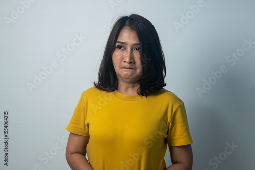 Asian women standing wearing yellow shirts emotional face and feeling grumpy frowning eyes brows look shocked expression annoyance dislikes