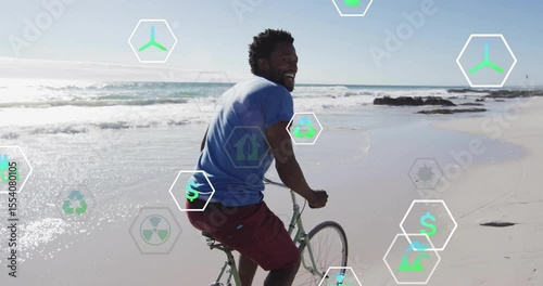 Man pedaling bicycle across wet sand, starting fading eco icons showing green energy benefits