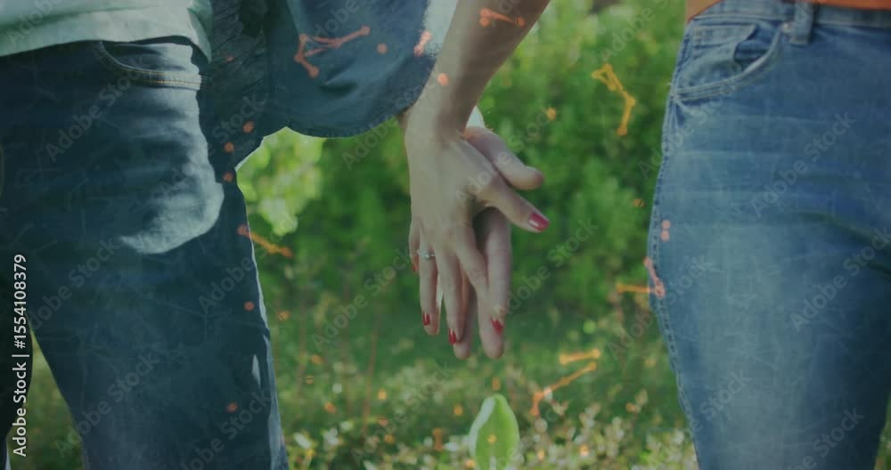 Couple walking through park bringing hands together and interlocking fingers showing health unity