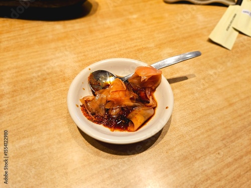 Spicy Korean kimchi served in a small bowl on a wooden table, suitable for Asian cuisine visuals, fermented food references, or healthy side dish stock