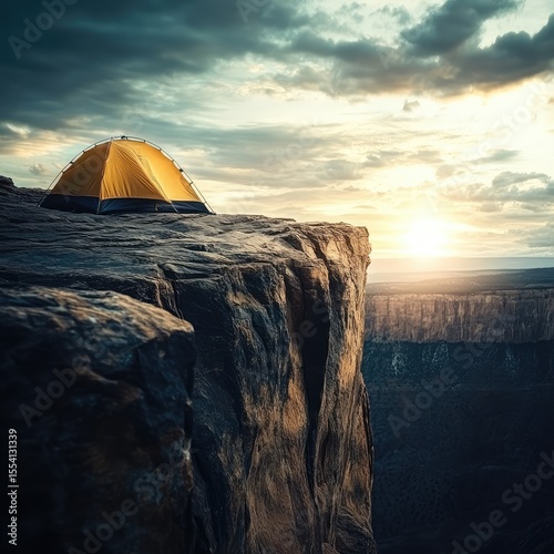 A yellow tent is on a cliff