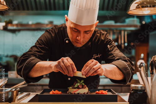 Restaurant's chef prepares a dish in the kitchen. Focus on the chef's hands.