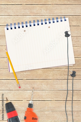 Tools and notepad on wooden background