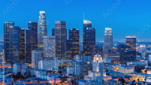 The los angeles city skyline at night features many illuminated skyscrapers against a dark blue sky