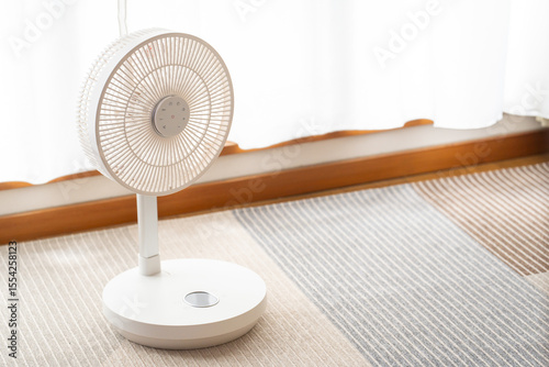 明るい室内に置かれた白い扇風機