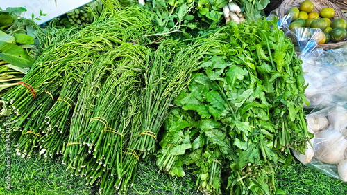 Fresh Greens from Local Market in Thailand: Vibrant display of fresh, leafy greens, climbing wattle, paco fern at a bustling market, showcasing an array of healthy, organic produce.