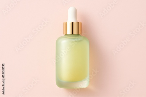 Frosted light green serum bottle with gold and white dropper on pink ground