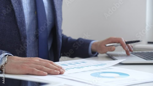 Professional analyzing financial charts on laptop, reviewing data for strategic business planning and investment optimization. Business people concept