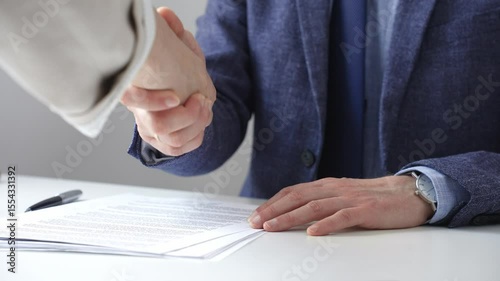 Business partners shaking hands at meeting after signing contract, finishing up collaboration or making successful deal. Business people concept