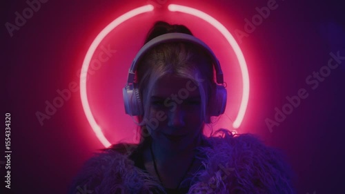 Woman DJ put on white headphones. Face of female disk jockey at neon techno club or rave
