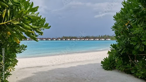 A deserted tropical beach and a calm ocean on a hot summer day.