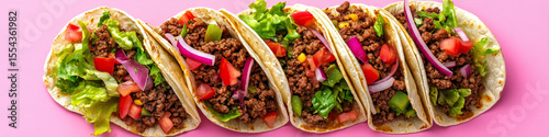 Row of Fresh Beef Tacos with Colorful Toppings on Pink