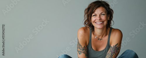 Joyful middle-aged woman with tattoo and friendly smile