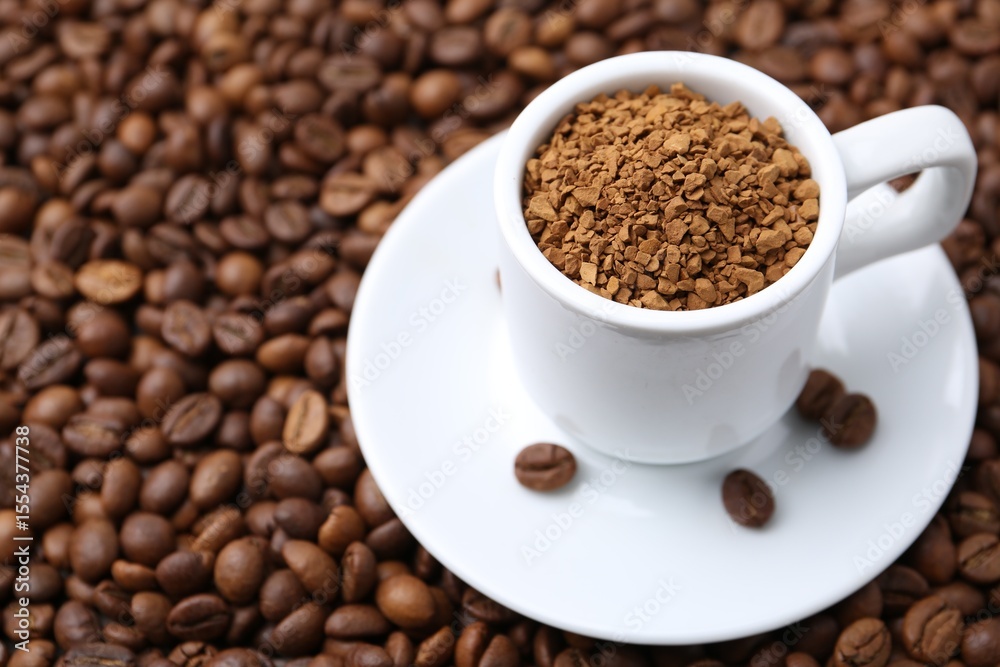 Obraz premium Cup with granulated instant coffee on beans, closeup. Space for text