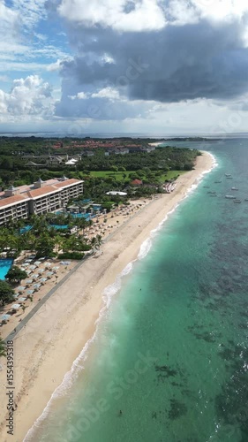 Aerial view of Bali island coastline, tropical beach with hotel at sunny day.Nusa Dua.Indonesia.Vertical video