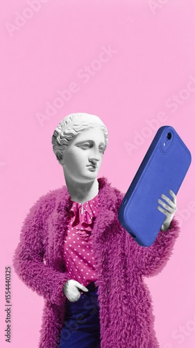 Loop animation. Woman with classical sculpture face takes selfie with giant phone, while wearing fuzzy pink coat. Concept of self-expression, social media, style, digital identity, surreal youth