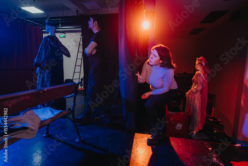 Tableau sur toile The backstage glimpse of a theater portrays actors preparing for a performance, surrounded by costumes and the warm glow of stage lights, capturing the artistry of theatrical productions