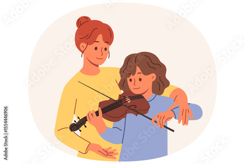Learning to play violin for teenage girl, from professional teacher who helps to hold bow correctly. Caring mother teaches daughter to perform music on violin, practicing before concert with audience