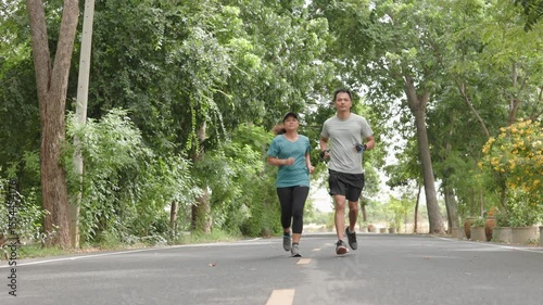 Asian working age men and women in their 50s and over are jogging together in the morning, with different poses and perspectives. Concept Healthy couple, encourage each other to exercise to be strong.