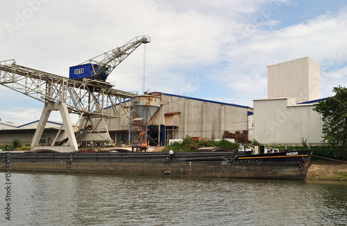 Riverside Industrial Site with Warehouses and Loading Crane 