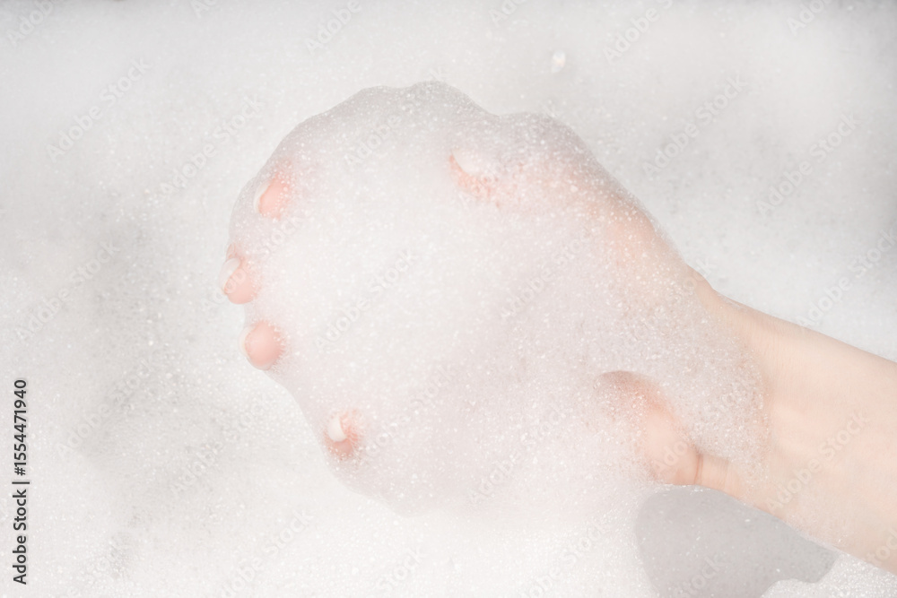 Fototapeta premium Female hands in foam close-up. girl's hands in soap foam. washing, cleaning, washing dishes