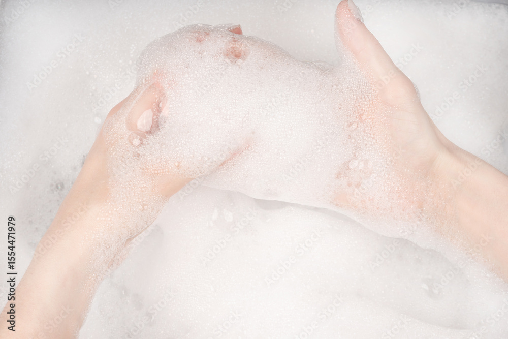 Fototapeta premium Female hands in foam close-up. girl's hands in soap foam. washing, cleaning, washing dishes